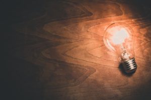 a lightbulb laying on a wooden surface.